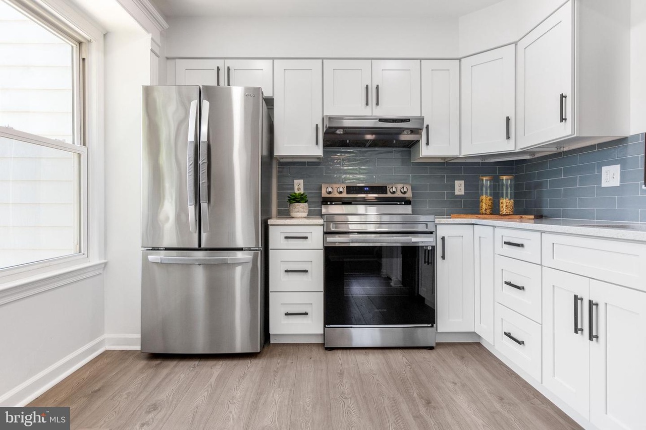 First time home buyer white kitchen cabinets & gray tiled backsplash