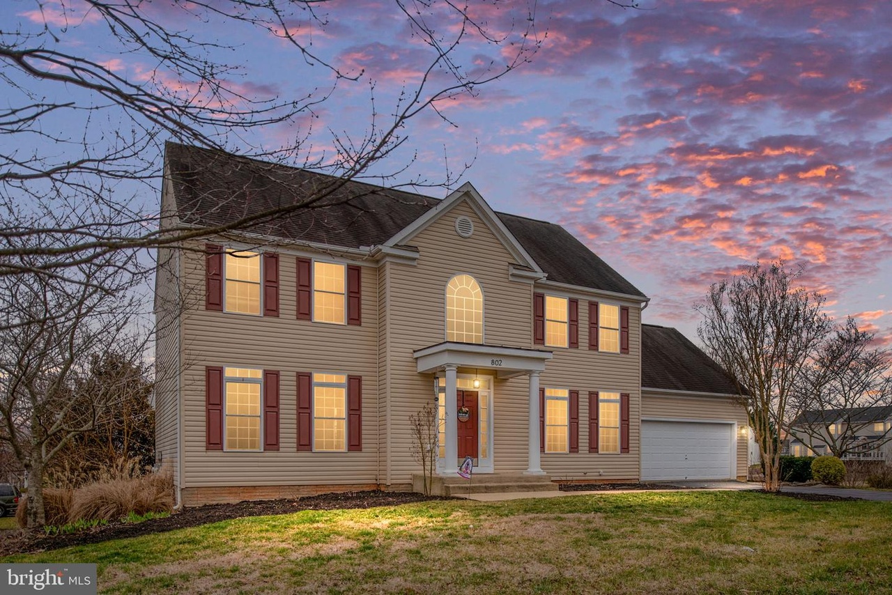 Two story home in Culpeper VA, lighted windows with sunset skies.