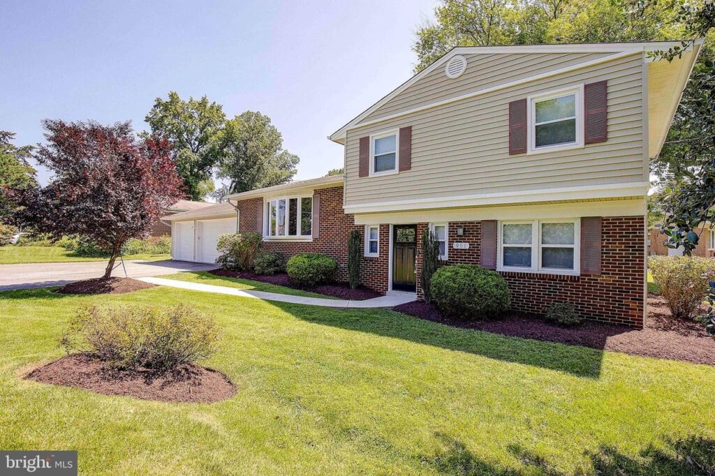 First time home buyer's home. Sidewalk through green lawn, brick and cream siding home.