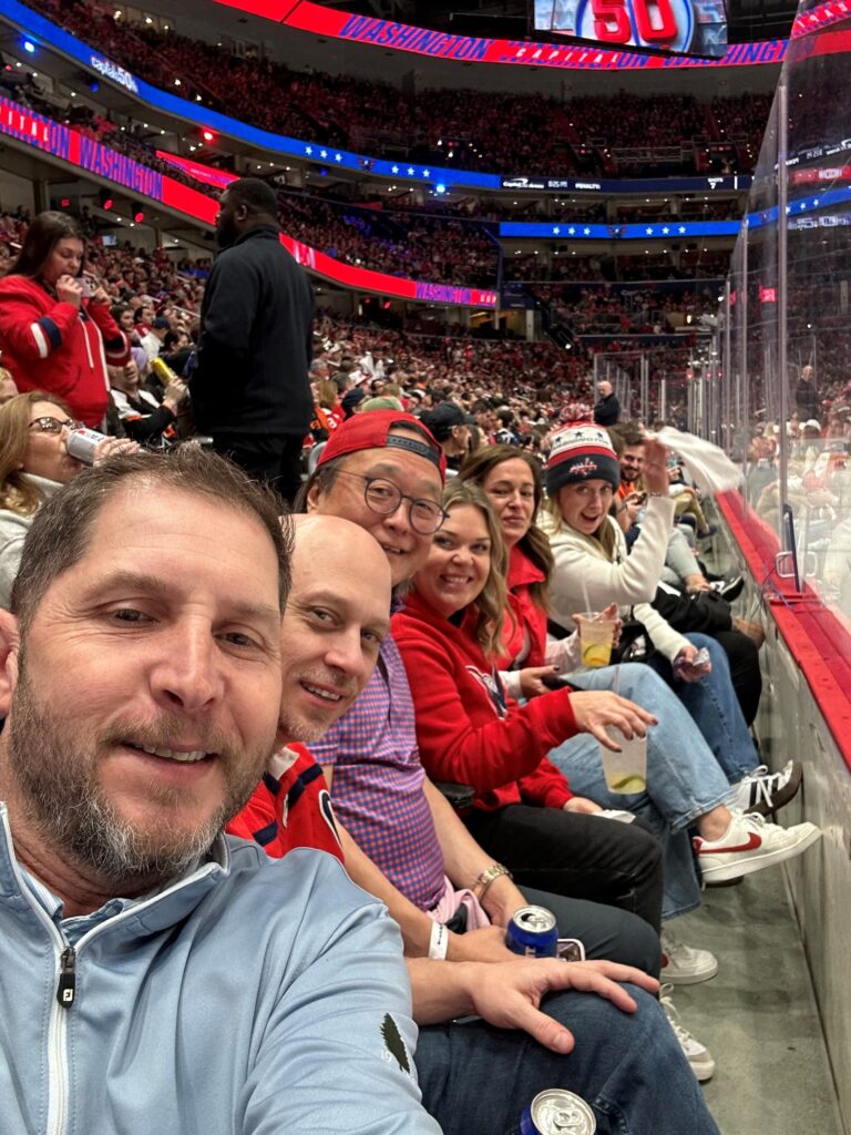 John at a hockey game sitting in the bleachers