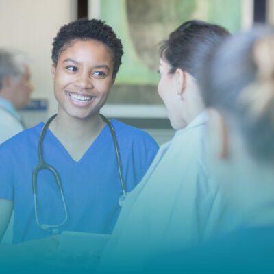 Travel Nurse looking at others with a smile, discussing short employment history