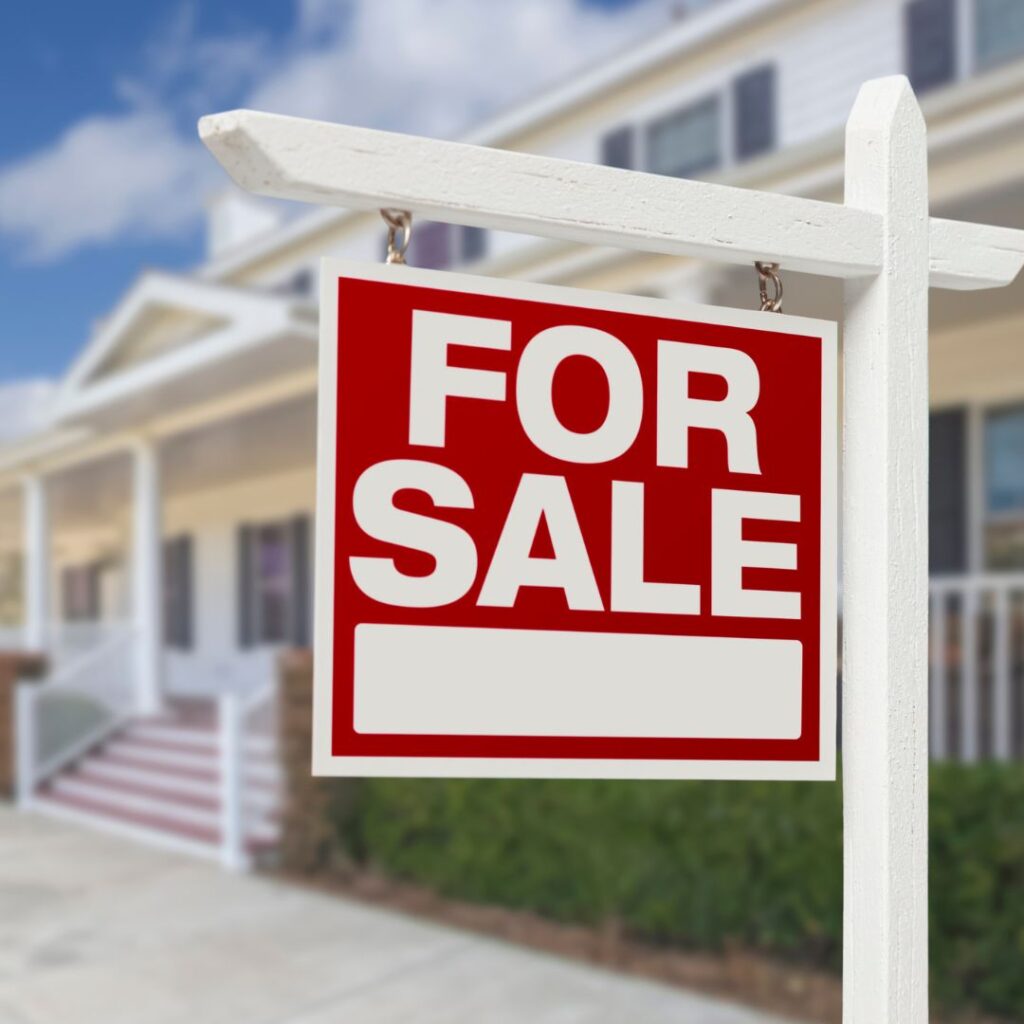 Spring real estate market for sale sign in front of homes, low inventory